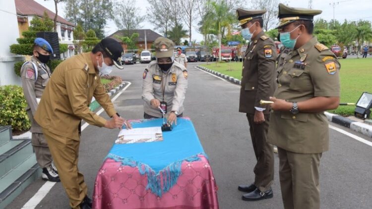 TEKEN SERTIJAB— Wako Pariaman Genius Umar meneken atau menandatangani berkas  serah terima jabatan (sertijab) Kepala Satuan Polisi Pamong Praja dan Pemadam Kebakaran (Satpol PP dan Damkar) dari Elfis Chandra kepada Alfian di Halaman Balaikota Pariaman.