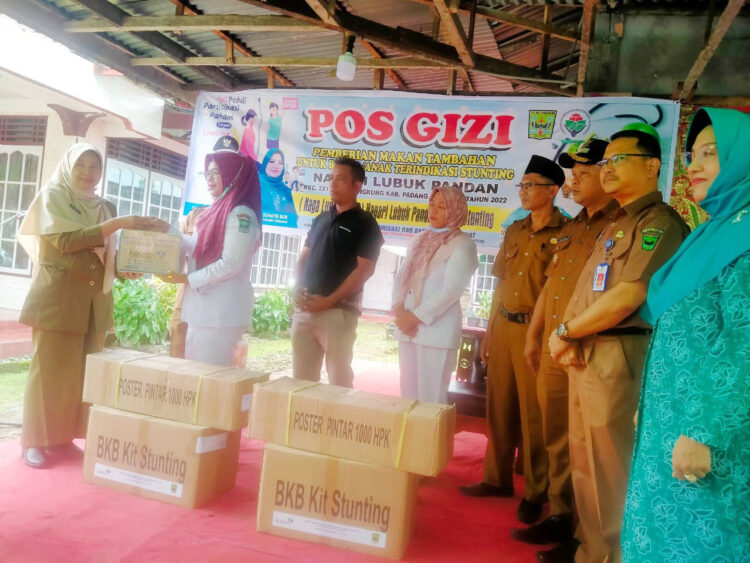 SERAHKAN BINGKISAN—Kadis DPPKB saat serahkan bingkisan kepada bidan saat acara launching disaksikan kads DPMD dan Walinagari.