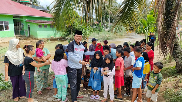 MENGHIBUR ANAK-ANAK— Mantan Bupati Limapuluh Kota Irfendi Arbi memberikan trauma healing kepada anak-anak korban terdampak banjir