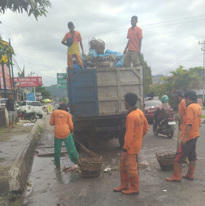 ANGKUT SAMPAH— Petugas kebersihan membersihkan tumpukan-tumpukan sampah yang semakin banyak ditemukan di pinggir jalan.