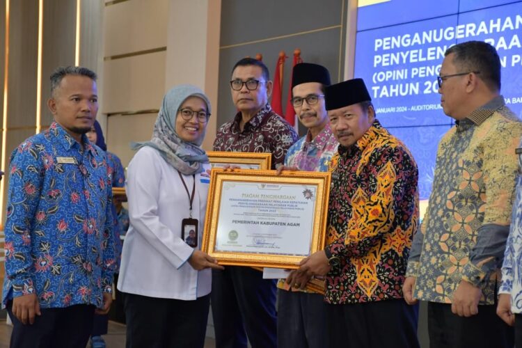 SERAHKAN PENGHARGAAN— Kepala Ombudsman Sumbar, Yefri Heriani menyerahkan penghargaan Kepatuhan Penyelenggaraan Pelayanan Publik tingkat Provinsi Sumatera Barat kepada Bupati Agam Andri Warman, di Auditorium Gubernur Sumbar, Senin (8/1).