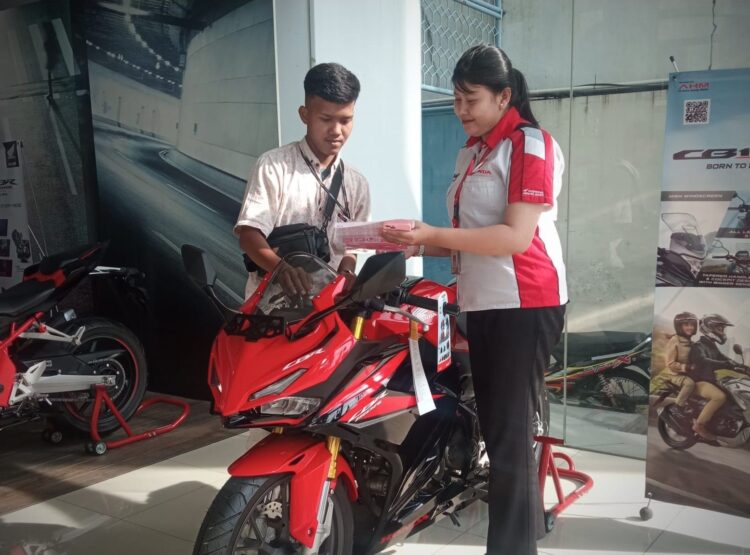 LAYANI KONSUMEN-Sales marketing PT Menara Agung melayani konsumen yang melakukan pembelian New Honda CBR150R.