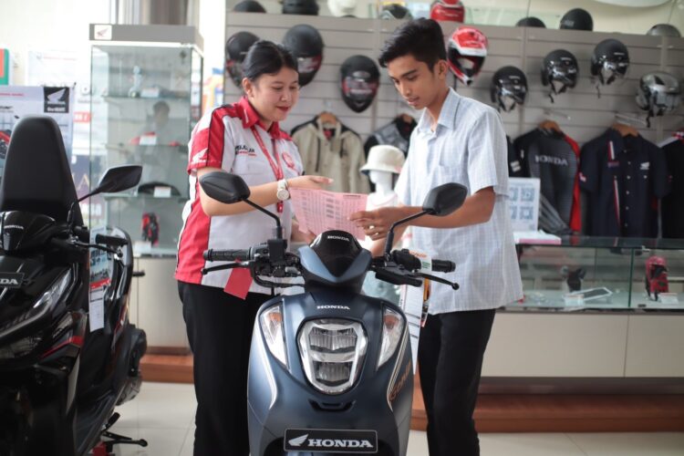 LAYANI KONSUMEN— Sales marketing PT Menara Agung melayani konsumen yang melakukan pembelian Honda Genio.