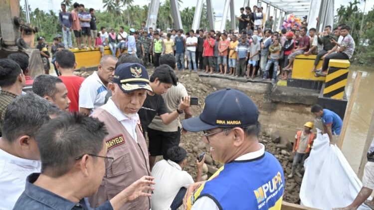 MENINJAU— Gubernur Mahyeldi saat meninjau salah satu ruas jalan nasional yang terban akibat tergerus
arus sungai di Kabupaten Pesisir Selatan