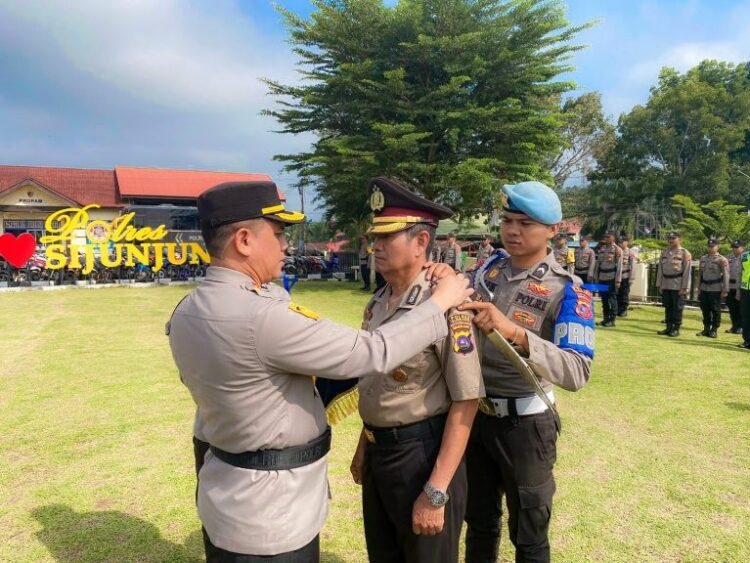 PASANGKAN—Kapolres Sijunjung AKBP Andre Anas pasangkan  pangkat pengabdian salah seorang personel di lingkungan Polres Sijunjung periode 1 Maret 2024.