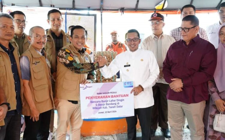 SERAHKAN BANTUAN— Pjs Direktur Utama Bank Nagari Gusti Chandra menyerahkan bantuan serahkan bantuan untuk korban bancana alam di Tanahdatar pada Bupati Eka Putra.