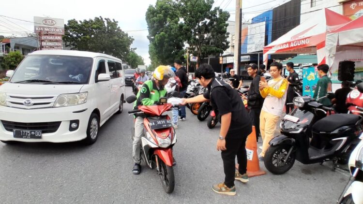 BAGI TAKJIL— Peserta Honda Cimmunity Bikers Soleh membagikan takjil di depan dealer PT Menara Agung, Jalan Veteran, Padang.