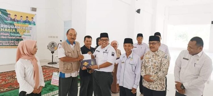 SERAHKAN—Bupati Padangpariaman Suhatri Bur saat menyerahkan  zakat kepada yang berhak menerimanya.