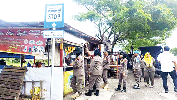 PEMBONGKARAN— Berjualan hingga menutupi halte Trans Padang Koridor 3 jurusan Air Pacah, di kawasan By Pass KM 7 Kecamatan Pauh, satu unit warung makanan ditertibkan dan dibongkar petugas Satpol PP, Selasa (21/5) siang.