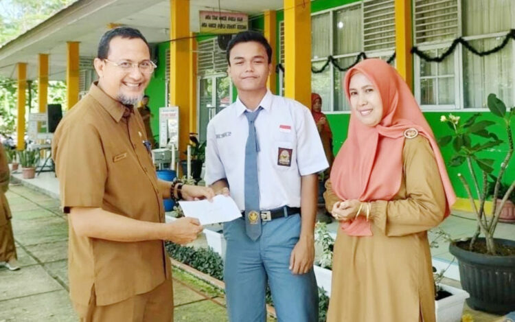 BERPRESTASI—  Cikal Perdana Putra (18), menerima hadiah dari gurunya dalam salah satu kegiatan classmeting. Selama duduk di bangku SMA, Cikal termasuk salah satu siswa yang selalu  masuk rangking 10 besar.