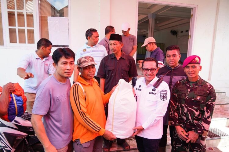 SERAHKAN BANTUAN— Bupati Eka Putra yang didampingi Komandan Batalyon Marhanlan II Padang Mayor Marinir Denny Aprianto Putro, serahkan bantuan korban galado di Kecamatan Batipuh dan Kecamatan X Koto, Jumat (17/5).