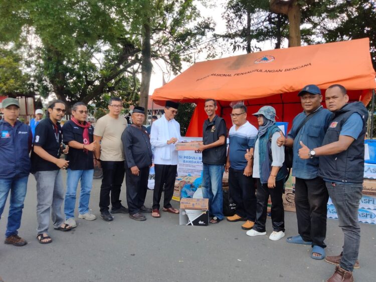 BANTUAN— Bupati Safaruddin menyerahkan donasinya untuk korban bencana alam galodo melalui BW yang diterima Ketua PWI Aspon Dedi di posko BW, di depan Tugu Adipura Kota Payakumbuh.