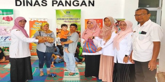 BANTUAN BAHAN PANGAN— Staf Ahli Bidang Pembangunan, Ekonomi dan Keuangan, Asfiyeni, serahkan bantuan bahan oangan pada petani.