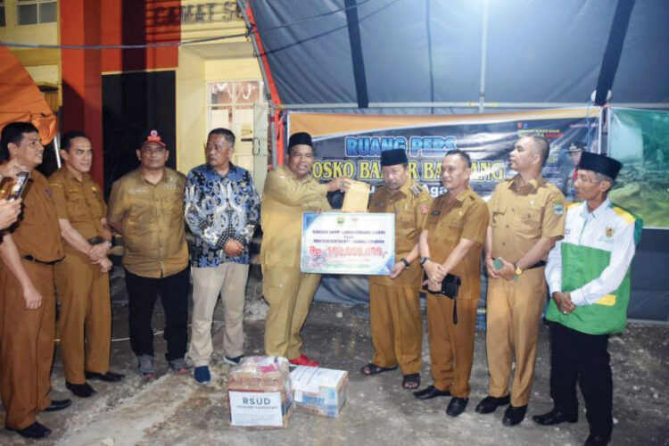 SERAHKAN BANTUAN— Bupati Padang Pariaman, Suhatri Bur mengantarkan langsung bantuan untuk korban bencana alam banjir bandang dan lahar dingin di Kabupaten Agam diterima oleh Bupati Agam Andri Warman di Posko Utama Bencana Alam, di Kantor Camat Sungai Pua, Senin (27/5).