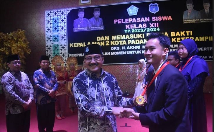 SERAHKAN IJAZAH— Kepala MAN 2 Kota Padang Akhri  Meinhardi, menyerahkan piagam ijazah kepada siswa tanda tamat di MAN 2 Padang, didampingi Kakanwil Kamenag Sumbar Mahyudin, dan Kamenag Kota Padang Edi Oktafiandi di acara perpisahan kelas XII MAN 2 Kota Padang.