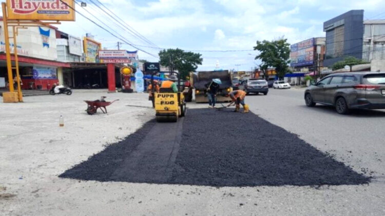 PENAMBALAN JALAN— Pemko Padang melalui Dinas PUPR melakukan penambalan dan pengecoran salah satu ruas jalan di  depan RM Lamun Ombak Ulak Karang.