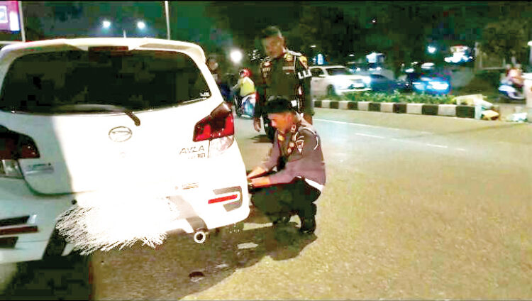 PARKIR DI TROTOAR— Petugas gabungan Satpol PP Kota Padang bersama Dinas Perhubungan (Dishub) kembali menggembosi kendaraan yang parkir di atas trotoar dan badan jalan, sepanjang jalan Khatib Sulaiman, Kecamatan Padang Utara, Rabu (26/6) malam.