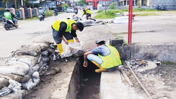 PEMBERSIHAN SALURAN DRAINASE— Petugas dari Dinas PUPR Kota Padang melakukan rehabilitasi saluran drainase dan pengerukan atau pembersihan sedimen. Hal ini sebagai antisipasi banjir di titik-titik rawan.