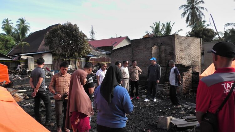 TINJAU—Bupati Pasaman Barat (Pasbar), Hamsuardi, didampingi oleh Kepala Pelaksana BPBD Jhon Edwar, Kepala Dinas Sosial Randy Hendrawan, Wali Nagari Sasak, Jorong Padang Halaban, dan stakeholder terkait meninjau sekaligus menyambangi korban kebakaran yang terjadi di Pasar Sasak Ranah Pasisie.