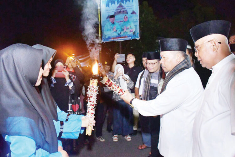 menerima api —Bupati Agam Andri Warman menerima api dari peserta tanda dimulainya pawai takbiran menyambut Idul Adha 2024, Minggu (16/6) malam.