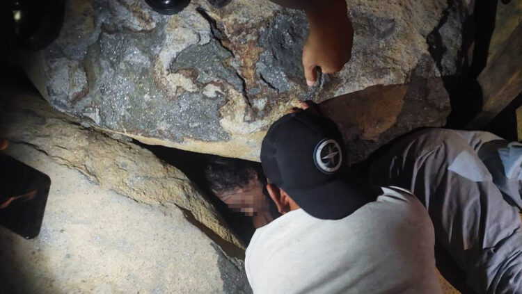 EVAKUASI— Personel Damkar Kota Padang melakukan evakuasi secara manual untuk mengeluarkan seorang gadis remaja yang terjepit dicelah batu grip Pantai Padang, atau di belakang kawasan Masjid Al Hakim Padang, Rabu (19/6) malam.