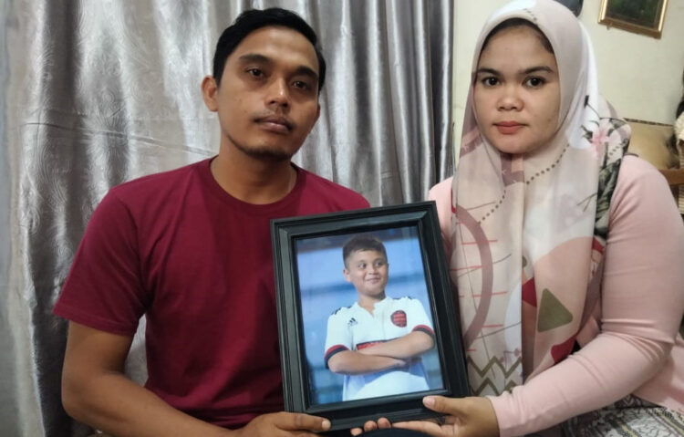 PERLIHATKAN FOTO— Afrinaldi dan Anggun Angriani, orang tua Afif Maulana memperlihatkan potret korban saat ditemui di kediamannya.