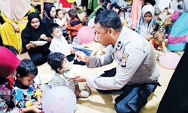 SUAPI ANAK— Aipda Dian menyuapi makanan bergizi pada seorang anak disaksikan orangtuanya saat melaksanakan program peduli anak stunting yang diberi nama “DAGOZI” (Dahsyat Go Gizi) Kecamatan Lubeg kota Padang, Jumat (31/5) yang lalu.