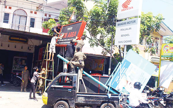 PENERTIBAN PAPAN REKLAME— Petugas Bapenda Kota Padang menertibkan sejumlah papan reklame yang habis masa tayang dan tidak memiliki izin, di kawasan Jati, Perintis Kemerdekaan, Andalas, Lubuk Lintah, Kamis (4/7).