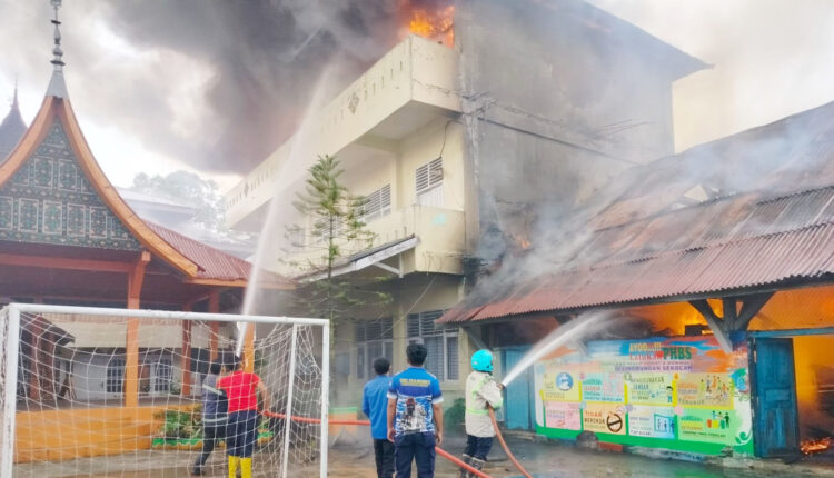 PEMADAMAN— Petugas Damkar melakukan penyemprotan air untuk memadamkan kebakaran yang melanda SMPN 1 Payakumbuh.