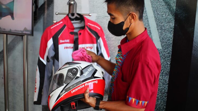 MERAWAT HELM-Karyawan PT Menara Agung memperagakan cara merawat helm.