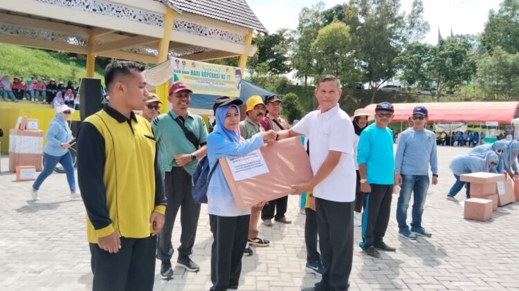 BERIKAN HADIAH— Sekda Limapuluh Kota Herman Azmar saat memberikan hadiah hiburan kim pada puncak peringatan hari Koperasi di Limapuluh Kota.