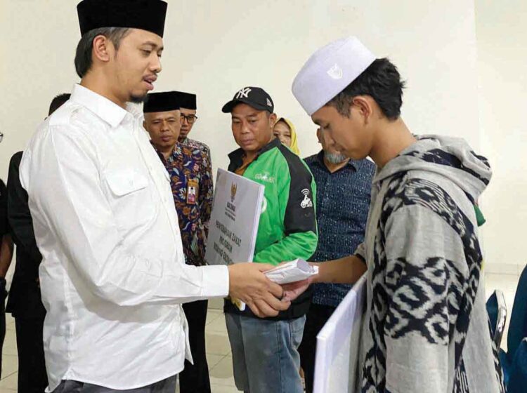 SIMBOLIS— Wako Erman Safar menyerahkan secara simbolis zakat untuk 196 mustahik dengan total bantuan sebesar Rp174 juta, Kamis (12/9) di Aula Baznas Bukittinggi.