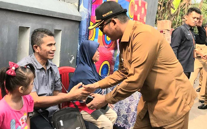 BERIKAN BANTUAN— Hendri Septa bersalaman dengan penyandang disabilitas setelah berikan bantuan usaha ekonomi produktif (pijat refleksi) sebagai bagian program turunkan angka kemiskinan saat jadi Wali Kota Padang.