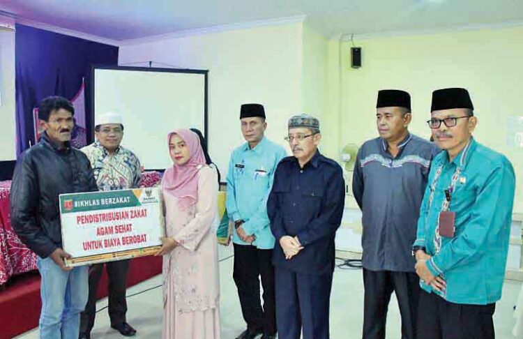 SIMBOLIS— Ketua LKKS Agam, Ny Yenni Andri Warman, menyerahkan secara simbolis Zakat, Infak dan Sedekah tahap II,
kepada 98 mustahik dari 2 Kecamatan, Kamis (19/9), di aula Kantor Camat Ampek Angkek.