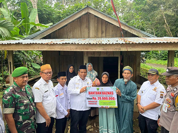 SERAHKAN BANTUAN REHAB RUMAH— Bupati Padangpariaman Suhatri Bur menyerahkan bantuan rehab Rumah Tidak Layak Huni (RTLH) untuk Eli Marlina,  orang tua dari almarhumah Nia Kurnia Sari, di Korong Pasa Surau, Nagari Guguak Kecamatan 2x11 Kayu Tanam, Padangpariaman.