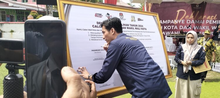 TANDATANGAN—Riyanda Putra menandatangani Deklarasi Damai pertama kali sebagai Paslon Nomor urut 1.