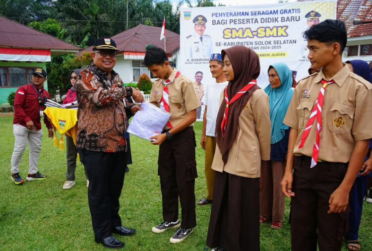 SERAHKAN—Sekda saat menyerahkan bantuan seragam gratis untuk siswa SMA N 2 Solok Selatan di Kantor Camat Sangir Jujuan.