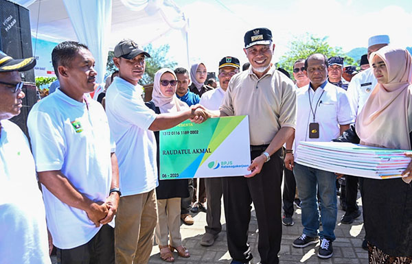 SERAHKAN BPJS— Gubernur Sumbar, Mahyeldi Ansharullah menyerahkan secara simbolis kepesertaan BPJS Ketenagakerjaan kepada nelayan di Pantai Air Bangis, Kabupaten Pasaman Barat, beberapa waktu lalu.