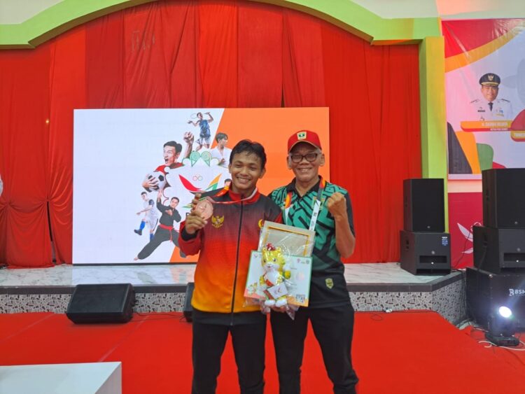 ATLET GULAT— M. Fauzan Al Ghifari (kiri) bersama manager tim gulat Sumbar, Ilmarizal.