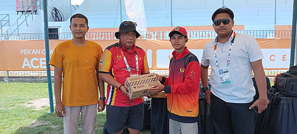 SERAHKAN SUPLEMEN— Panitia Kontingen PON Sumbar menemui atlet F9U Daniel Danuarta dan menyerahkan bantuan minuman suplemen di Stadion Sabang-Merauke saat berlatih jelang laga Senin mendatang.