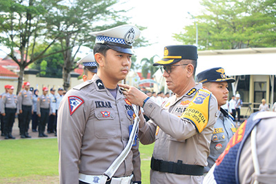 OPERASI— Irwasda Polda Sumbar, Kombes Pol Prabowo Santoso memasang tanda Operasi Zebra Singgalang 2024 kepada personel dalam apel gelar pasukan.