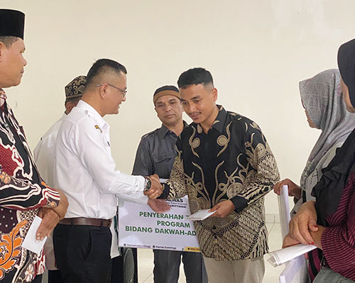 SIMBOLIS— Kabag Kesra Kota Bukittinggi, perwakilan Kementerian Agama, dan Ketua Baznas Bukittinggi menyerahkan secara simbolis zakat kepada 137 mustahik.