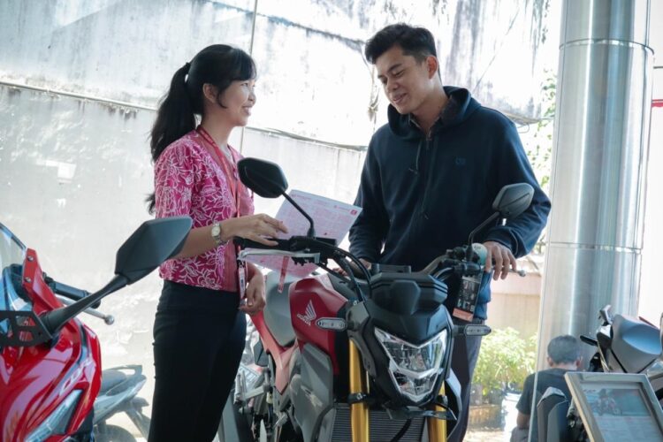 LAYANI KONSUMEN-Sales marketing PT Menara Agung melayani konsumen yang melakukan pembelian All New Honda CB150R.