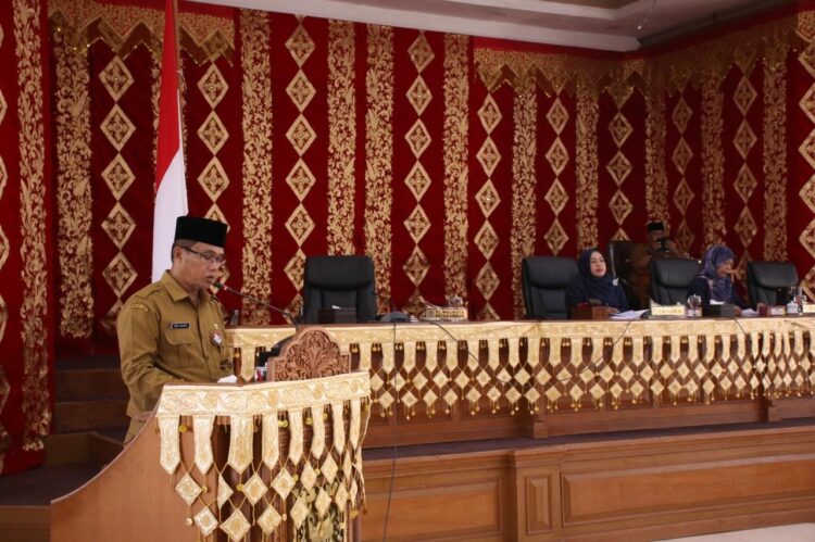 BACAKAN NOTA KEUANGAN— Sekdako Payakumbuh, Rida Ananda dalam sidang paripurna DPRD Kota Payakumbuh membacakan nota keuangan APBD 2025.