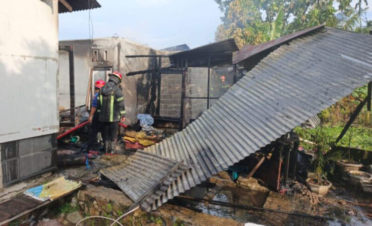 KEBAKARAN— Petugas Damkar melakukan penyemprotan air untuk memadamkan api yang membakar tiga rumah di Padang.