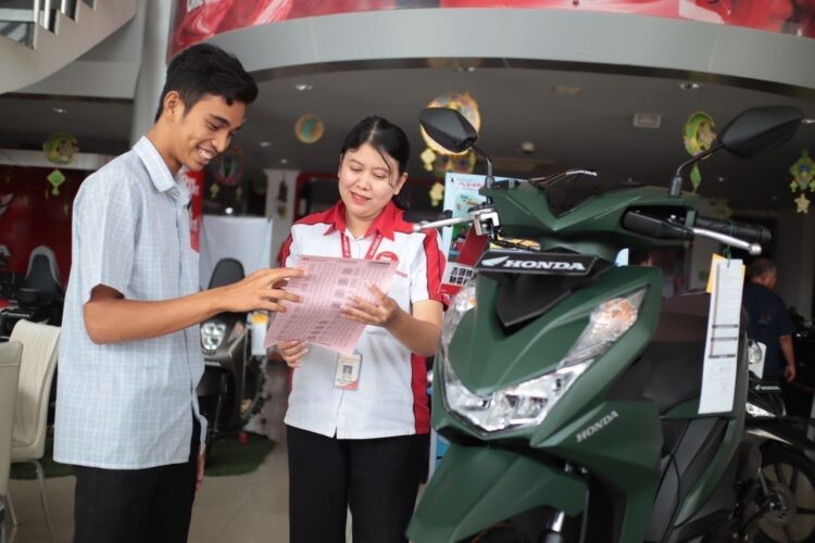 LAYANI KONSUMEN-Sales marketring PT Menara Agung melayani konsumen yang melakukan pembelian New Honda BeAT.
ist