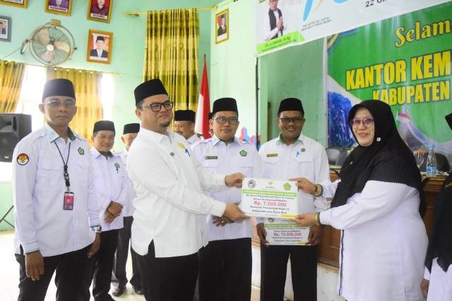 SERAHKAN BANTUAN— Kepala Baznas disaksikan Kalankemnag H.Irwan disaksikan Kasi Penmad H.Rizki Eka Putra menyerahkan bantuan kepada kepala madrasah.