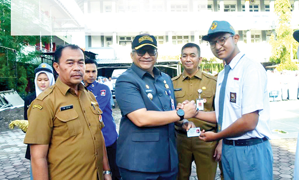 SERAHKAN E-KTP— Pj Wali Kota Padang Andree Algamar menjadi pembina upacara di SMAN 10 Padang, sekaligus menyerahkan e-KTP secara simbolis kepada 34 orang siswa, Senin (11/11) pagi.