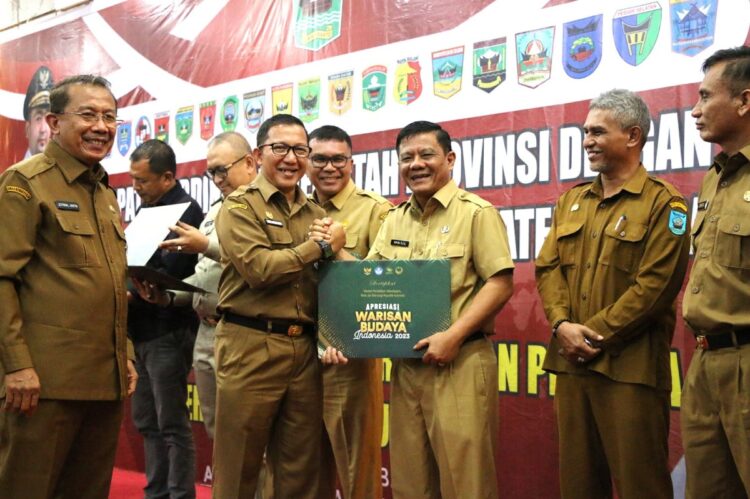 TERIMA PENGHARGAAN—Pj Sekdako Pariaman Yaminu Rizal saat  menerima penghargaan yang diserahkan Pj Sekretaris Daerah Yaminu Rizal pada kegiatan Rapat Koordinasi Pemerintah Provinsi dengan Pemerintah Kabupaten/Kota se Sumatera Barat, beberapa waktu lalu.