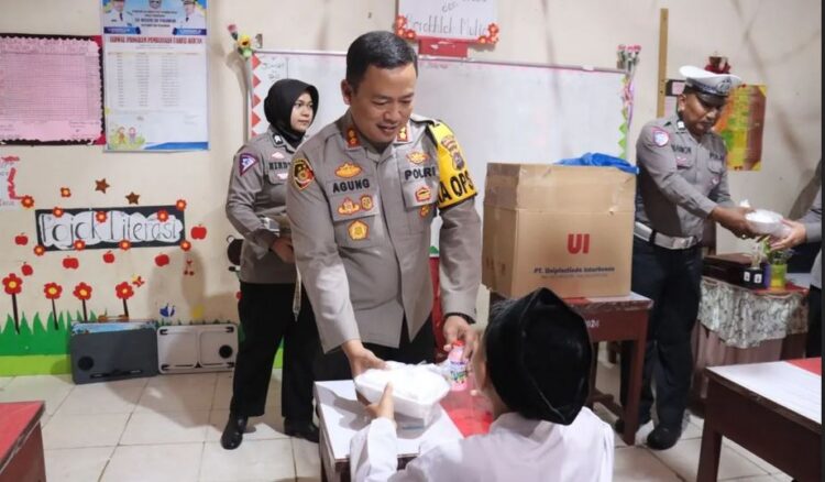 BAGIKAN PAKET MAKAN GRATIS— Kapolres Pasaman Barat AKBP Agung Tribawanto membagikan makanan bergizi gratis kepada siswa di SD 09 Pasaman Jorong Pasaman Baru, Nagari Lingkuang Aua Baru, Kecamatan Pasaman.